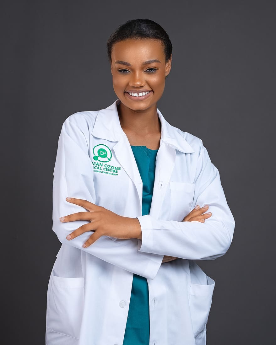 Smiling female doctor in a white lab coat with "German Ozone Medical Centre" logo, arms crossed, against a dark gray background.