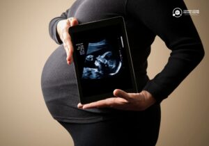 Pregnant woman holding ultrasound scan on a tablet, showcasing successful conception