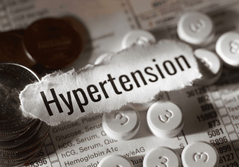 Hypertension concept with tablets and medical chart background.